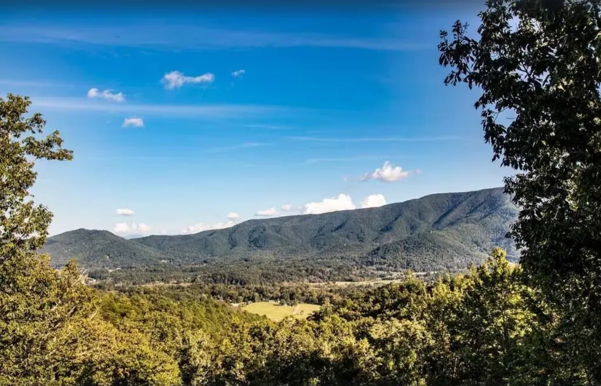 This image captures a sweeping view of the Smoky Mountains, with lush forested slopes, a valley below, and a vibrant sky above. The landscape is inviting and full of natural beauty, perfectly reflecting the abundant outdoor adventure opportunities described in the section.